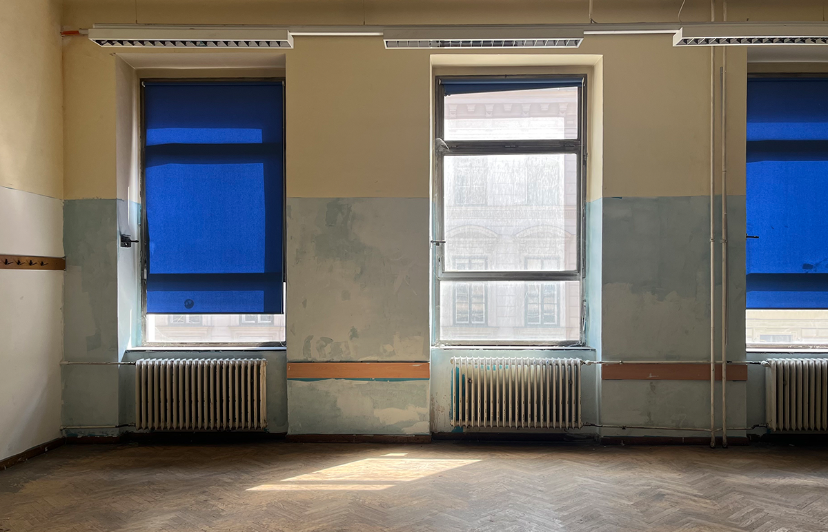 leeres Klassenzimmer, Blick Richtung Fenster mit blauen Jalousien