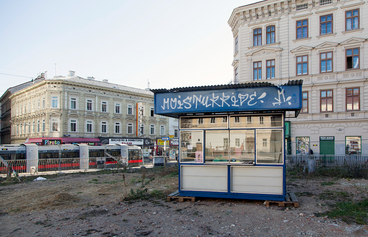 Ein blau-weißer Kiosk steht aut der leeren Fläche.