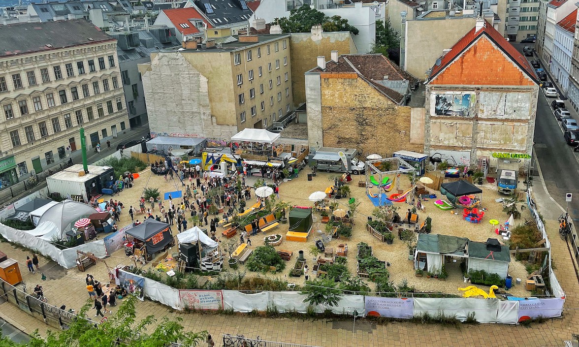 Wild im West von oben, man sieht viele Menschen, Container, Schirme und Begrünung